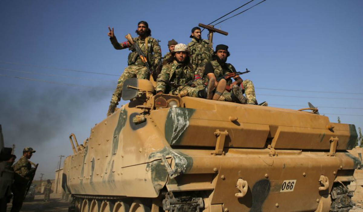 Combatientes sirios respaldados por Turquía avanzan en un vehículo blindado en los vecindarios del suroeste de la ciudad siria fronteriza de Tal Abyad| AFP