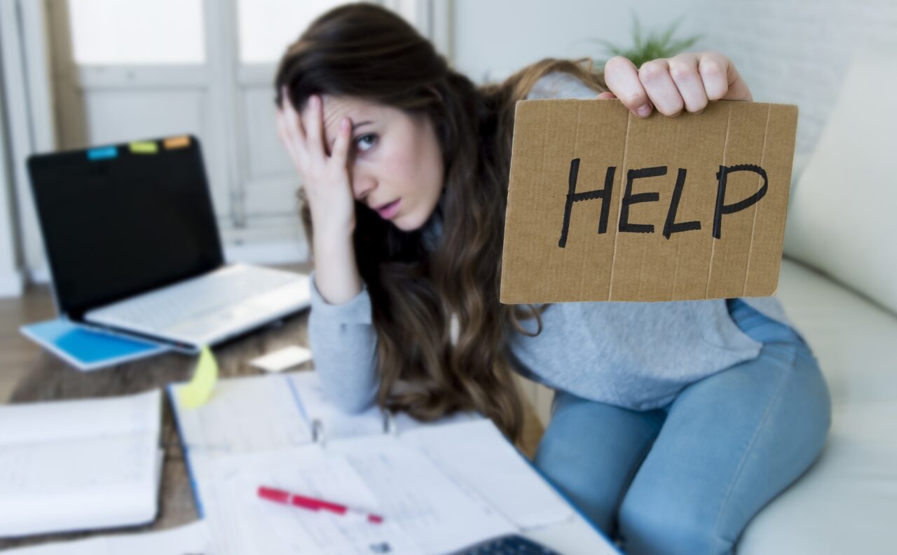 young woman suffering stress doing domestic accounting paperwork bills